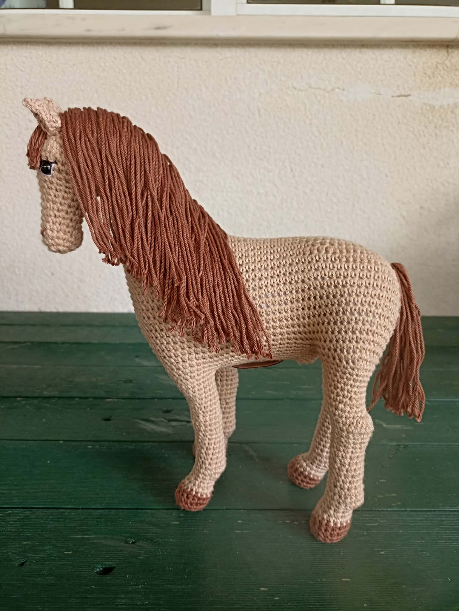 Handmade crochet amigurumi horse, with a brown mane and beige body