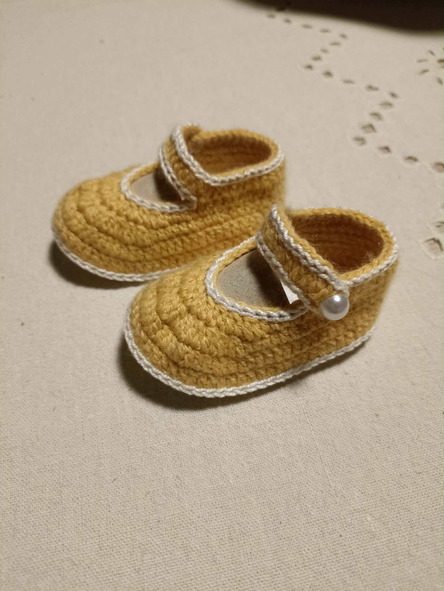 Baby crochet booties with pearly button fastening