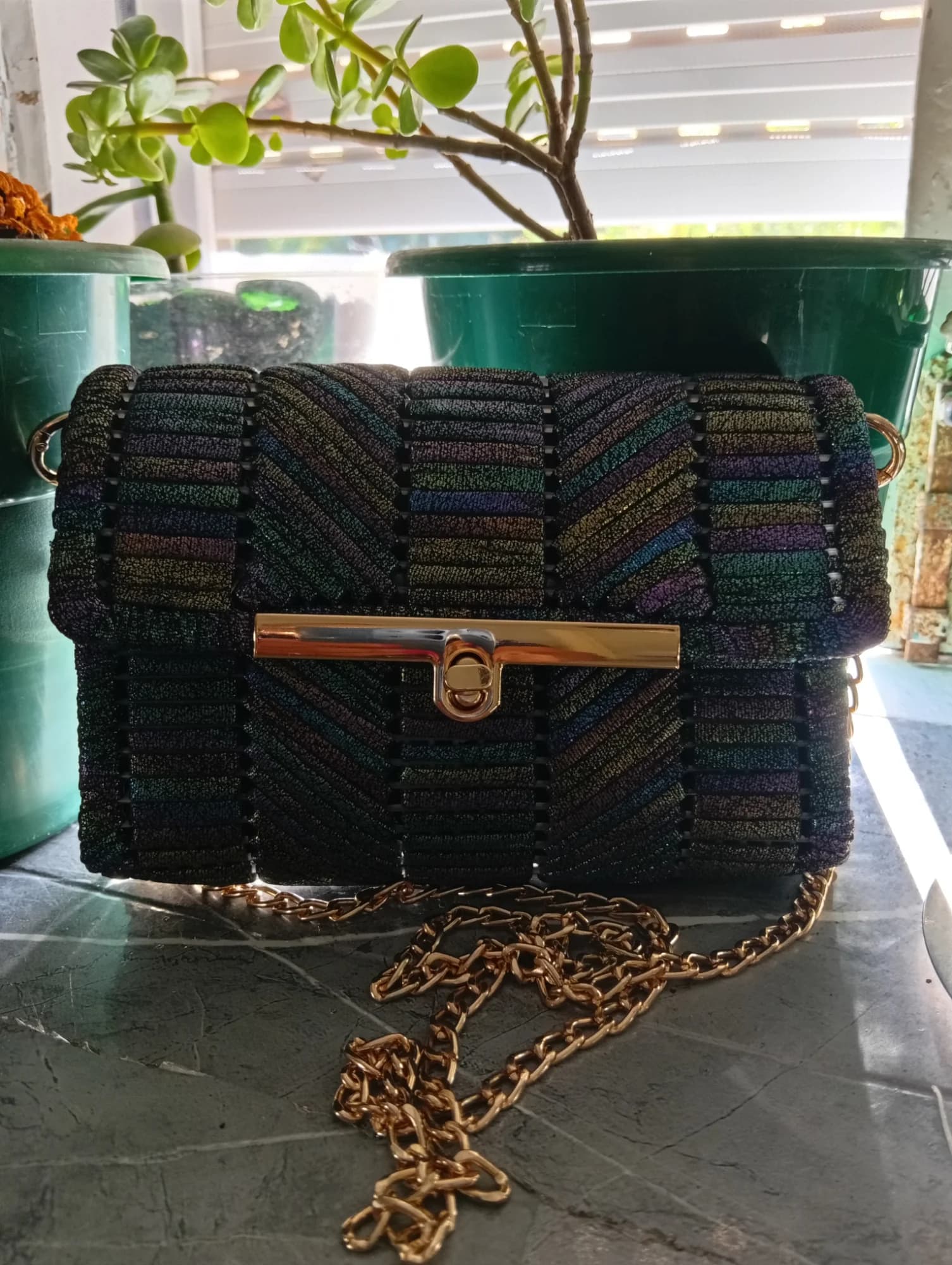 Clutch preta em croché com fecho dourado e alça de corrente.